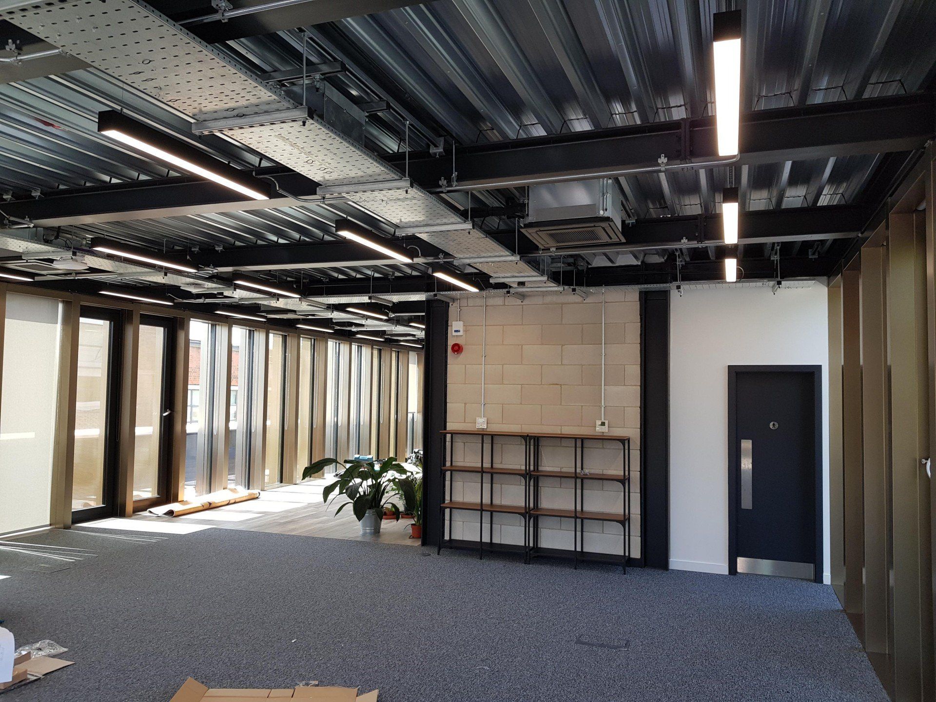 A large empty room with a door and shelves