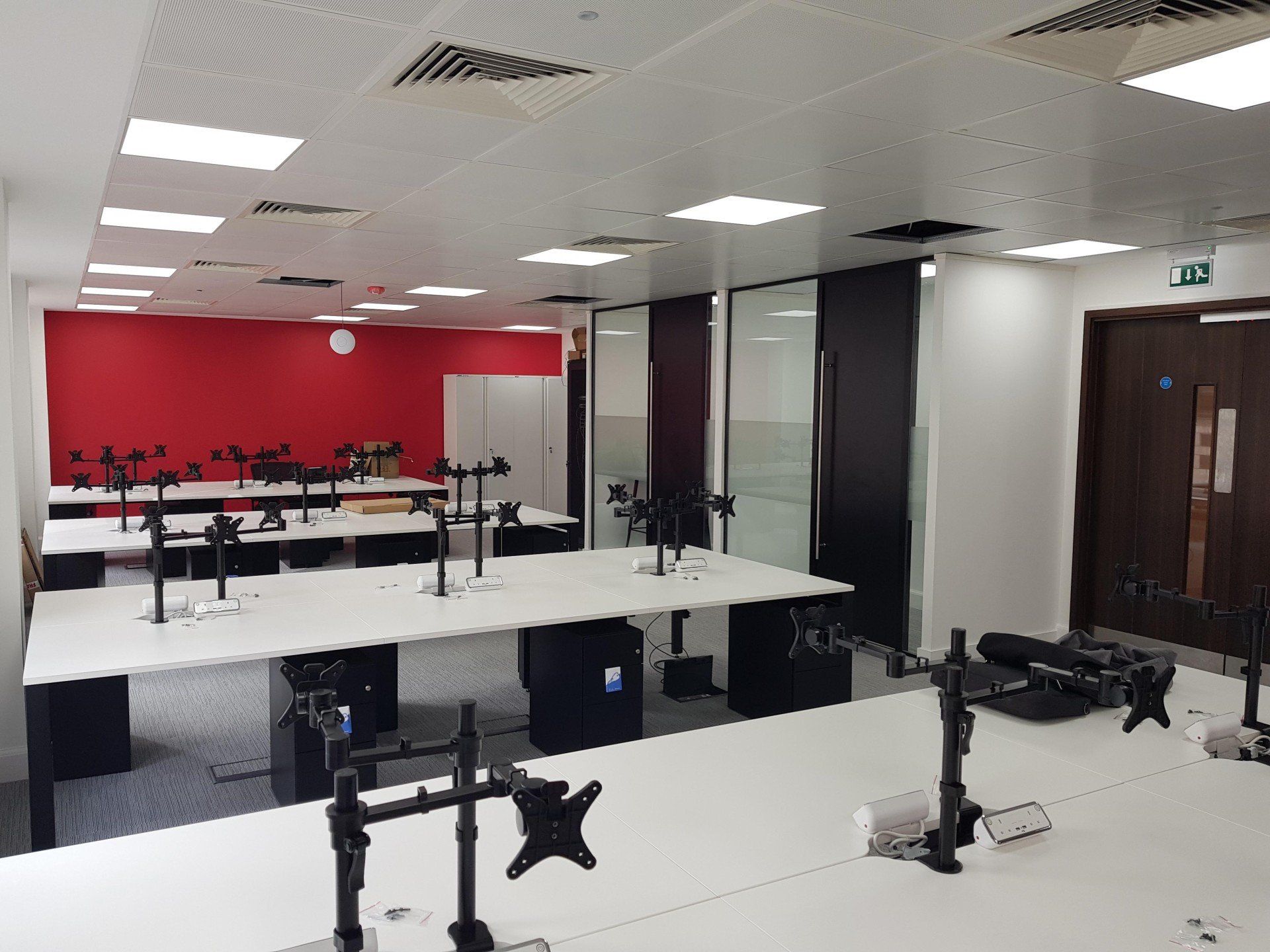 A large office with a lot of desks and monitors.