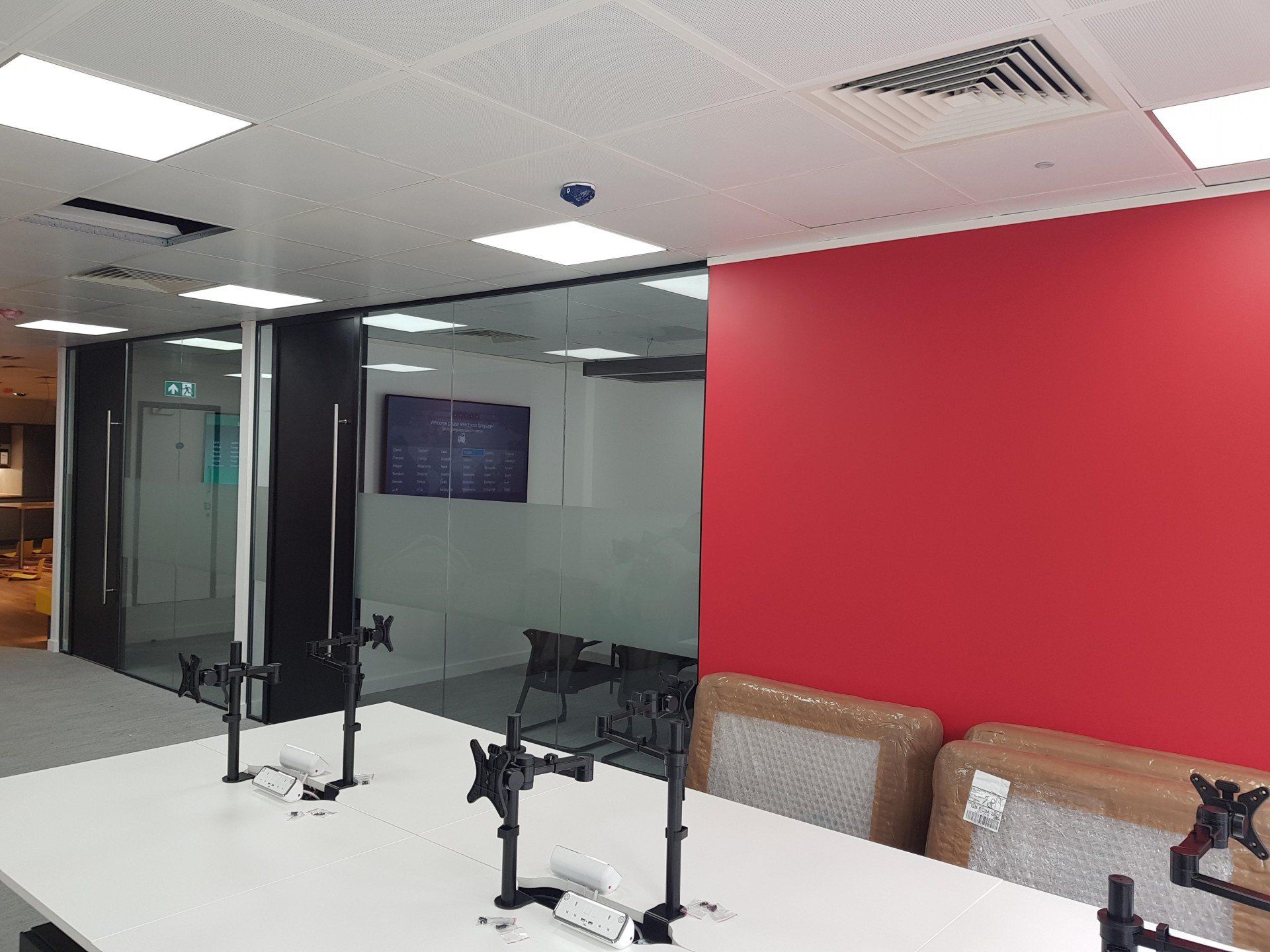 A conference room with a long table and a red wall.