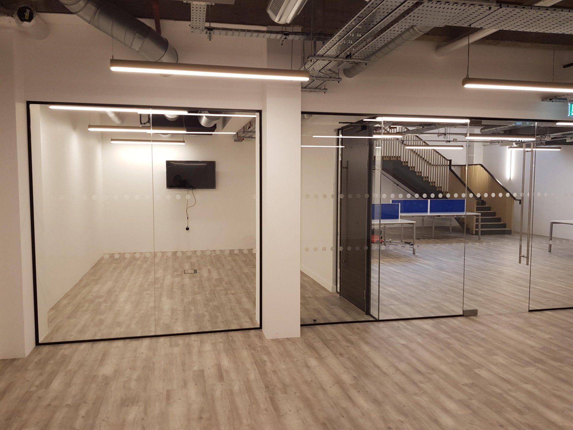 A large room with a lot of glass doors and a flat screen tv on the wall.