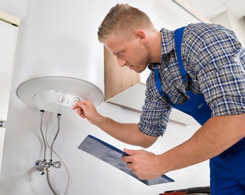 Worker Adjusting Temperature Of Water Heater — Moline, IL — Erickson Plumbing & Heating