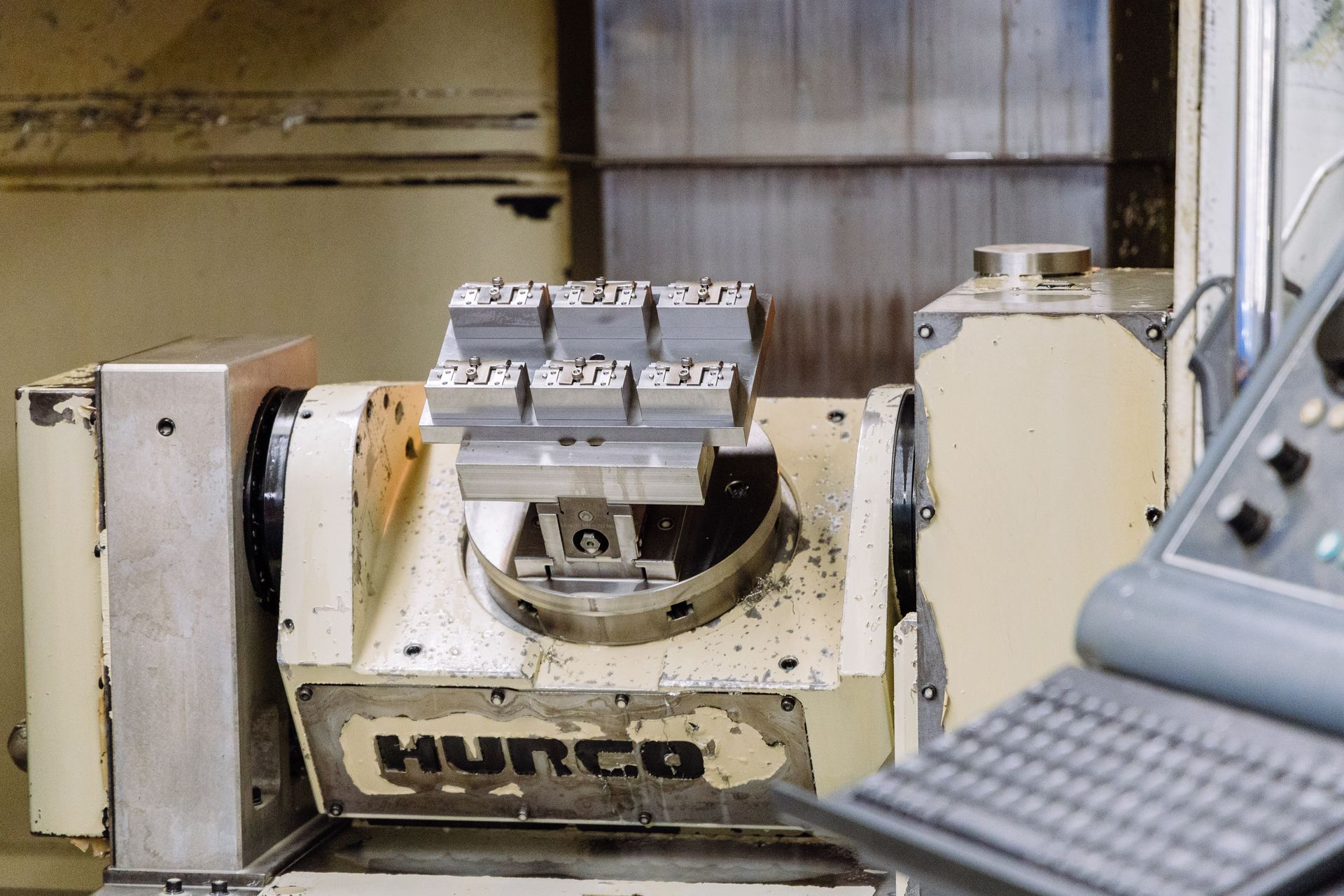 A hurco machine is sitting on a table next to a keyboard