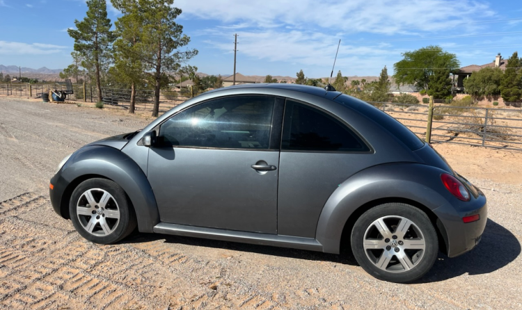 A volkswagen beetle is parked on the side of a dirt road. | Wind River Auto & Diesel