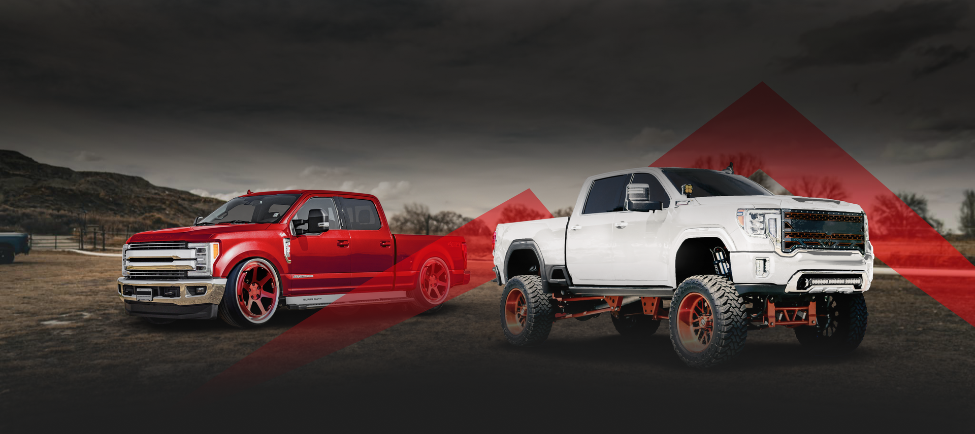 A red and a white truck are parked next to each other on a dirt road. | Wind River Auto & Diesel