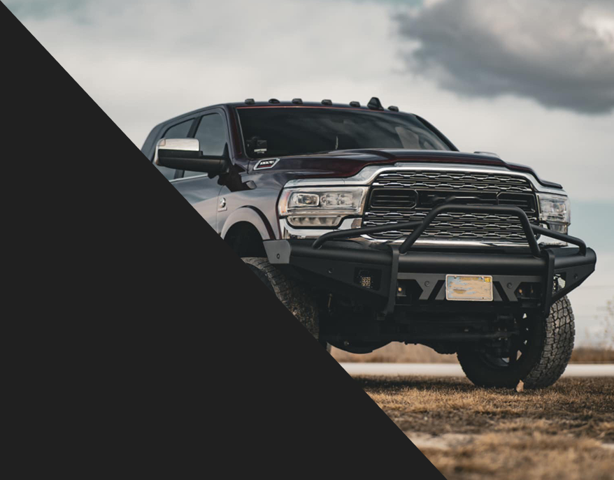 A ram truck is parked on a dirt road. | Wind River Auto Diesel