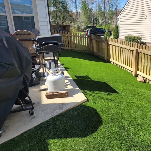 A backyard with a grill and a propane tank
