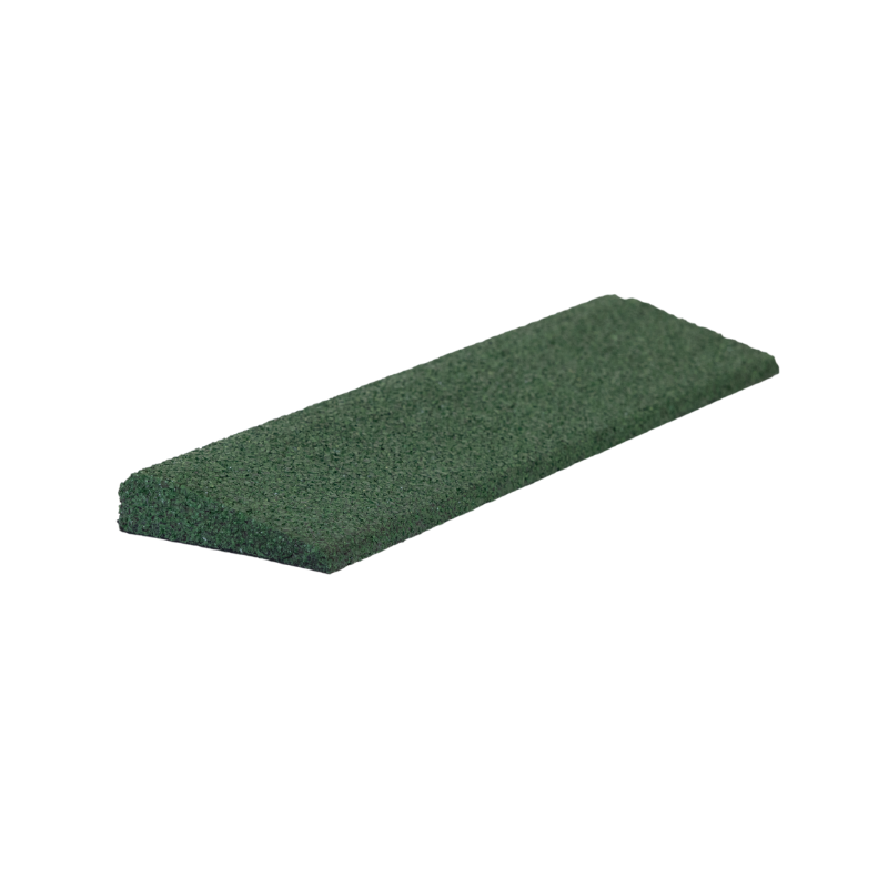 A green sponge is sitting on a white surface.