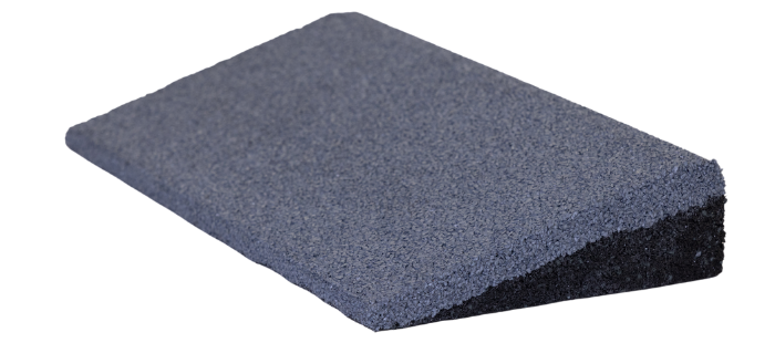 A black rubber wedge is sitting on a white surface.