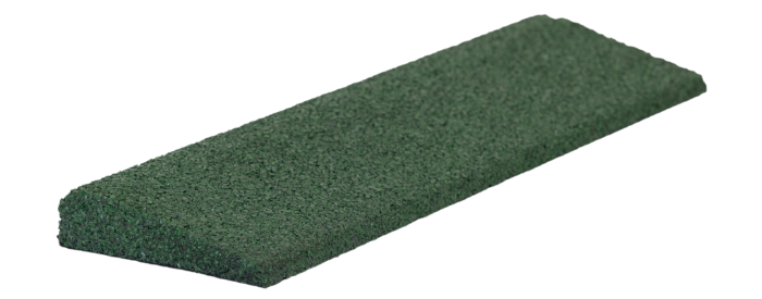 A green sponge is sitting on a white surface.