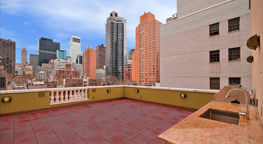 A rooftop with a sink and a view of the city