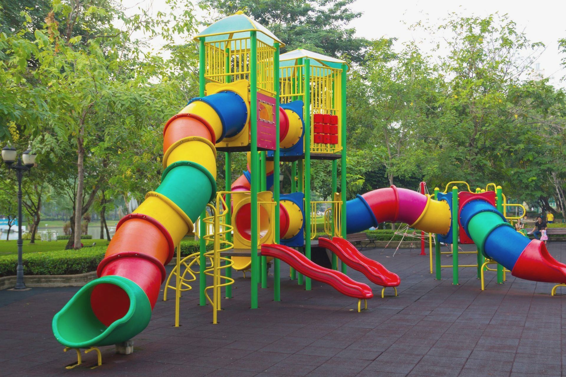 A colorful playground in a park with trees in the background