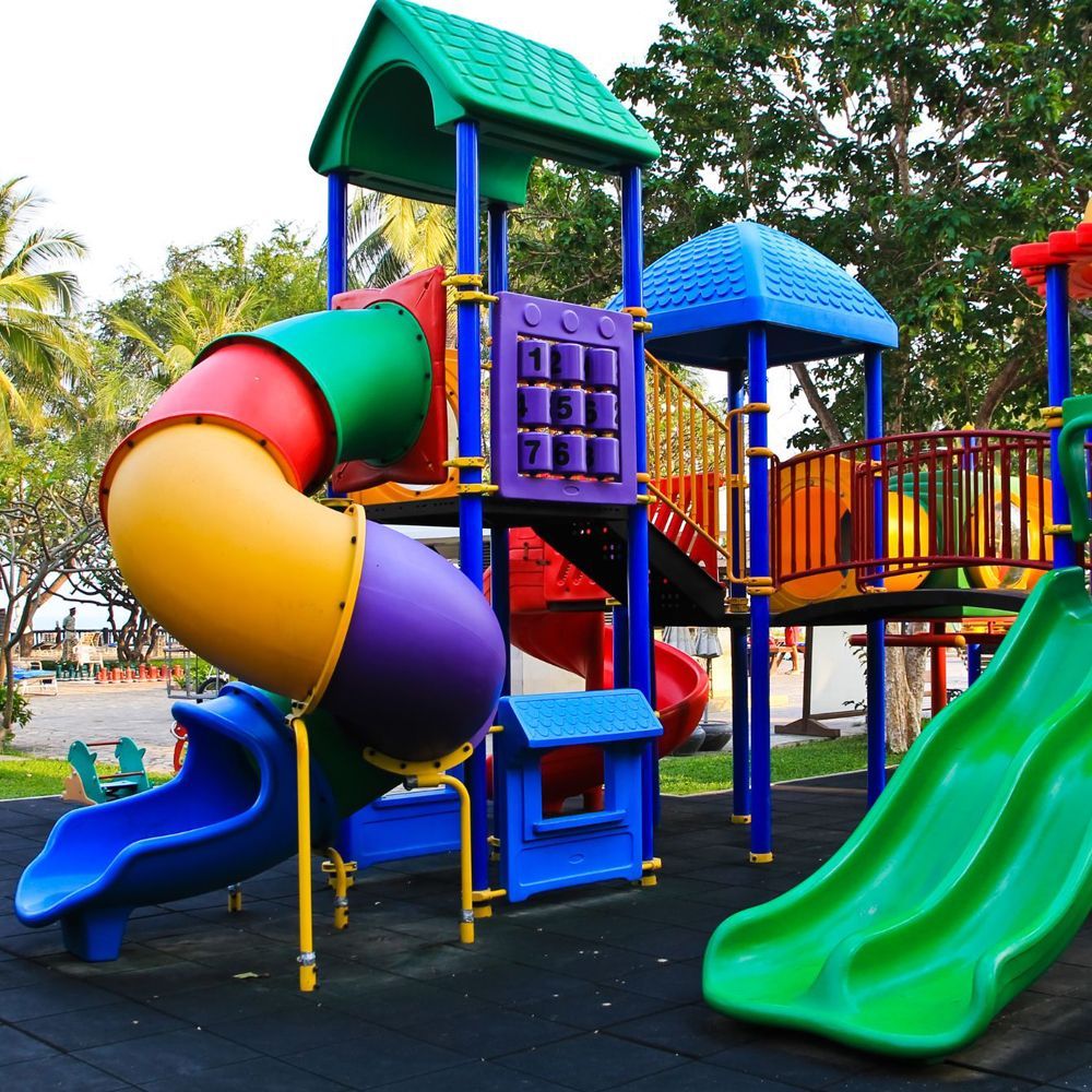 A colorful children 's playground with a green slide