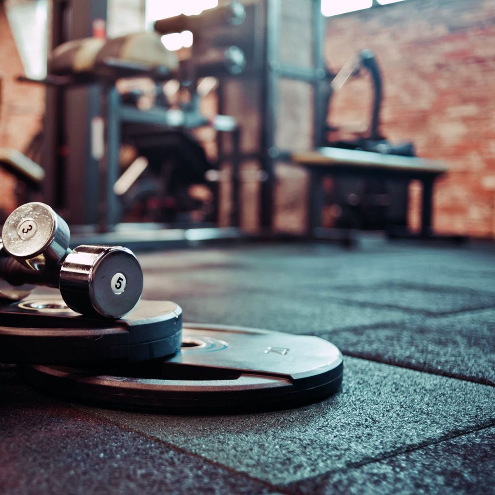 A pair of dumbbells sitting on top of a stack of weights in a gym.