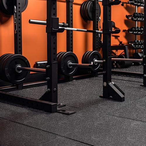 A row of squat racks with barbells in a gym