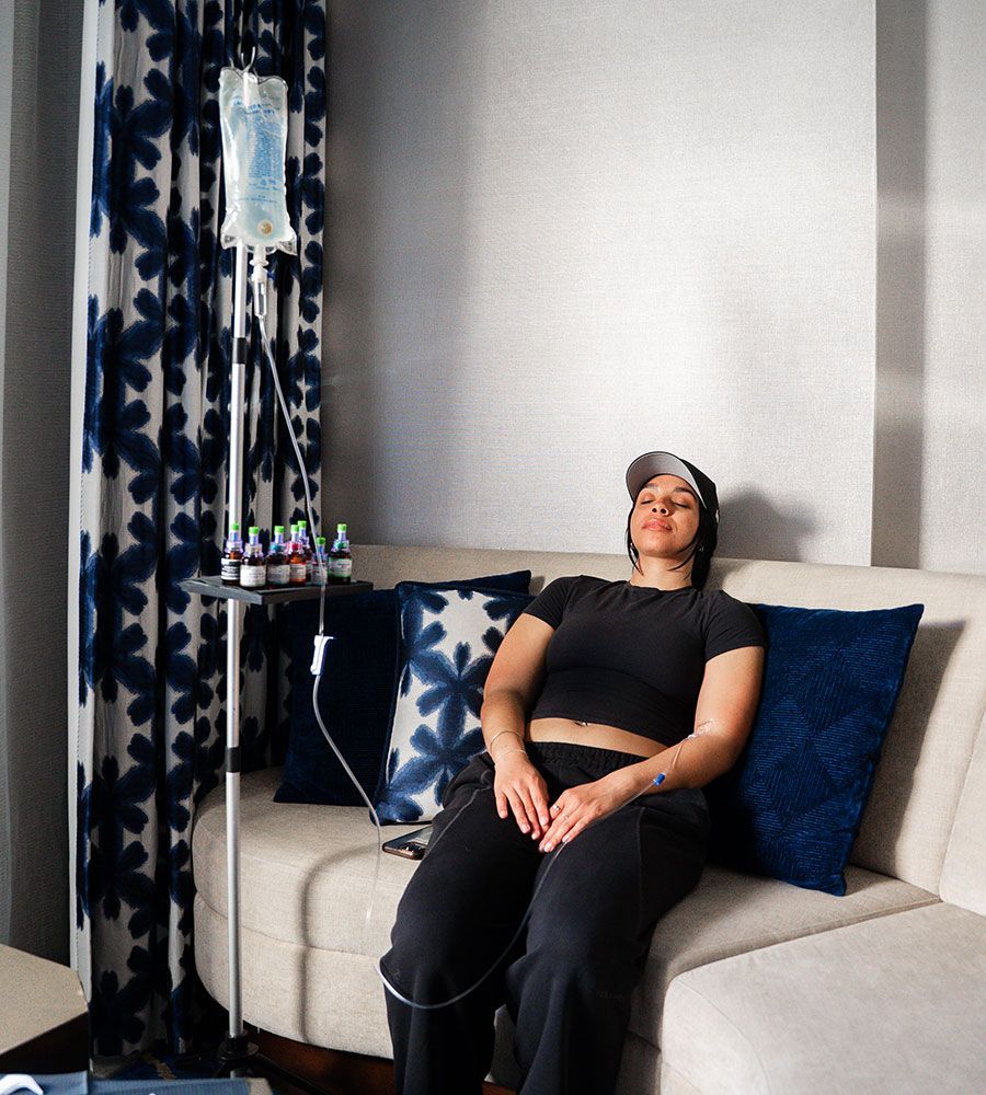 In-room IV therapy for stress relief and wellness, showing the client enjoying a peaceful moment during the convenient, non-disruptive treatment session in a hotel or home setting.