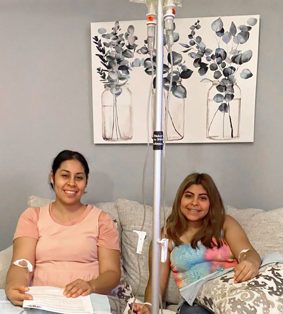 A family of four sitting together on a couch receiving simultaneous mobile IV treatments.