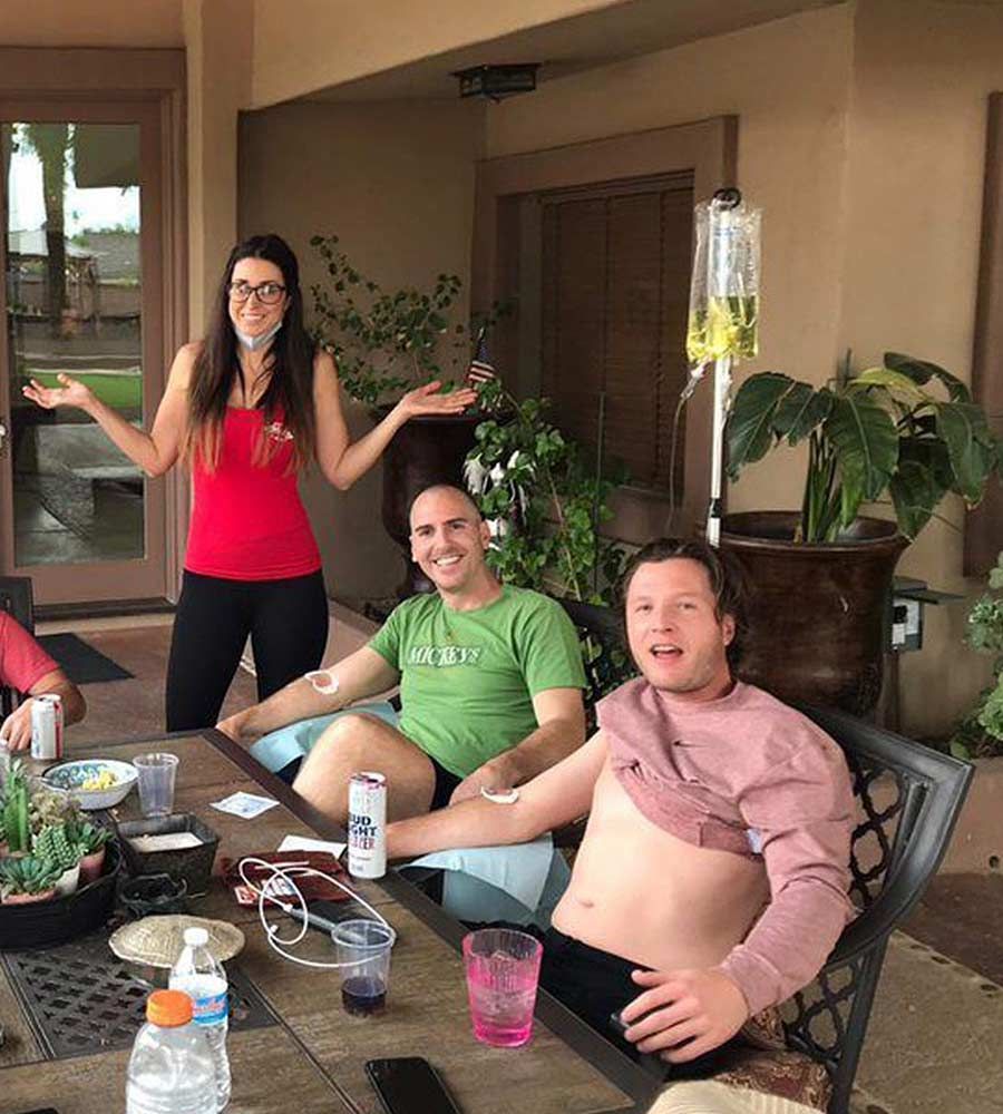 Outdoor mobile IV hydration for a group or party, providing recovery and wellness services on a home patio.