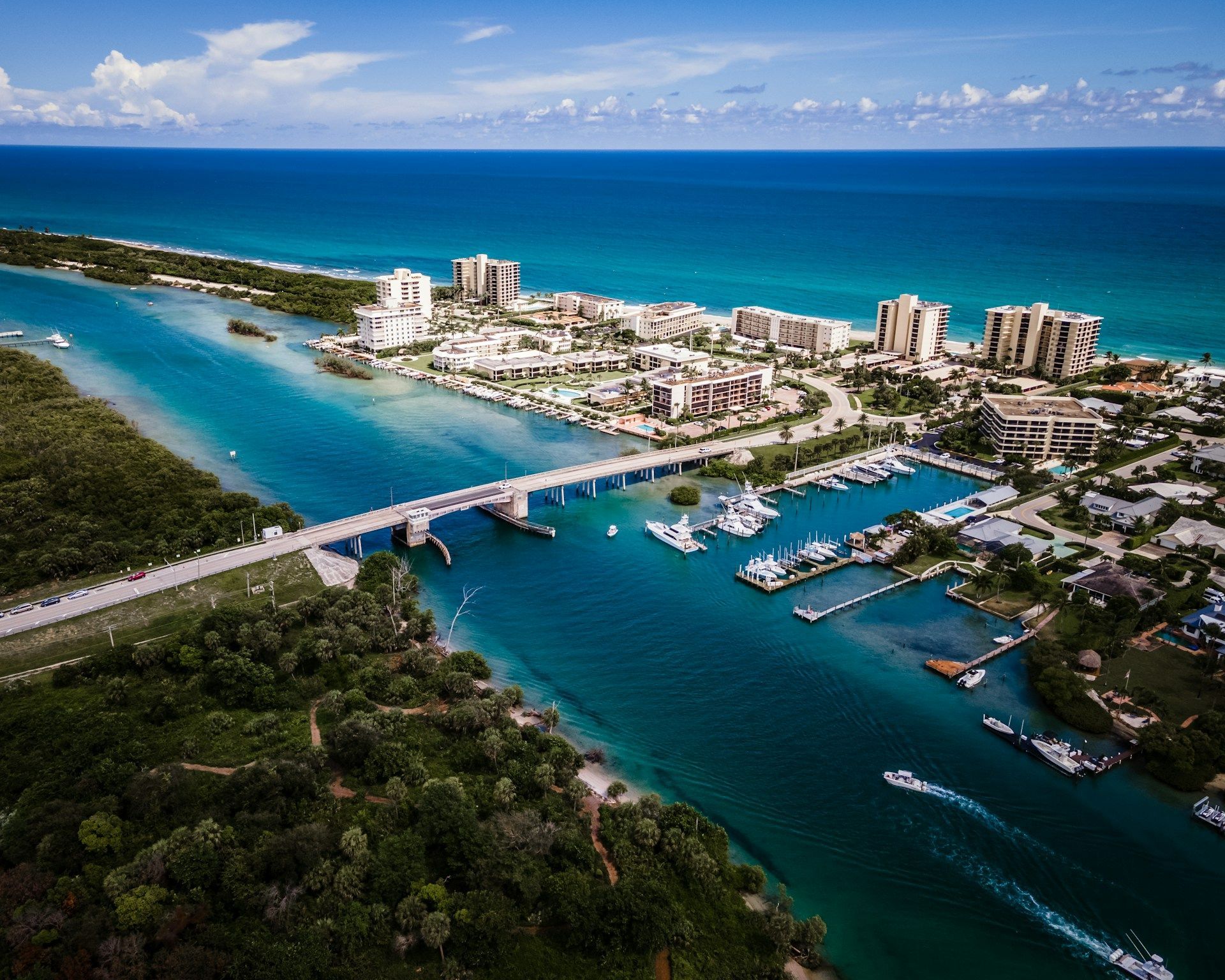 Aerial view of a coastal town with a bridge over a waterway to the ocean.