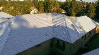 Metal Roof Installation — Worker Installs Metal Roof in Orange Beach, AL