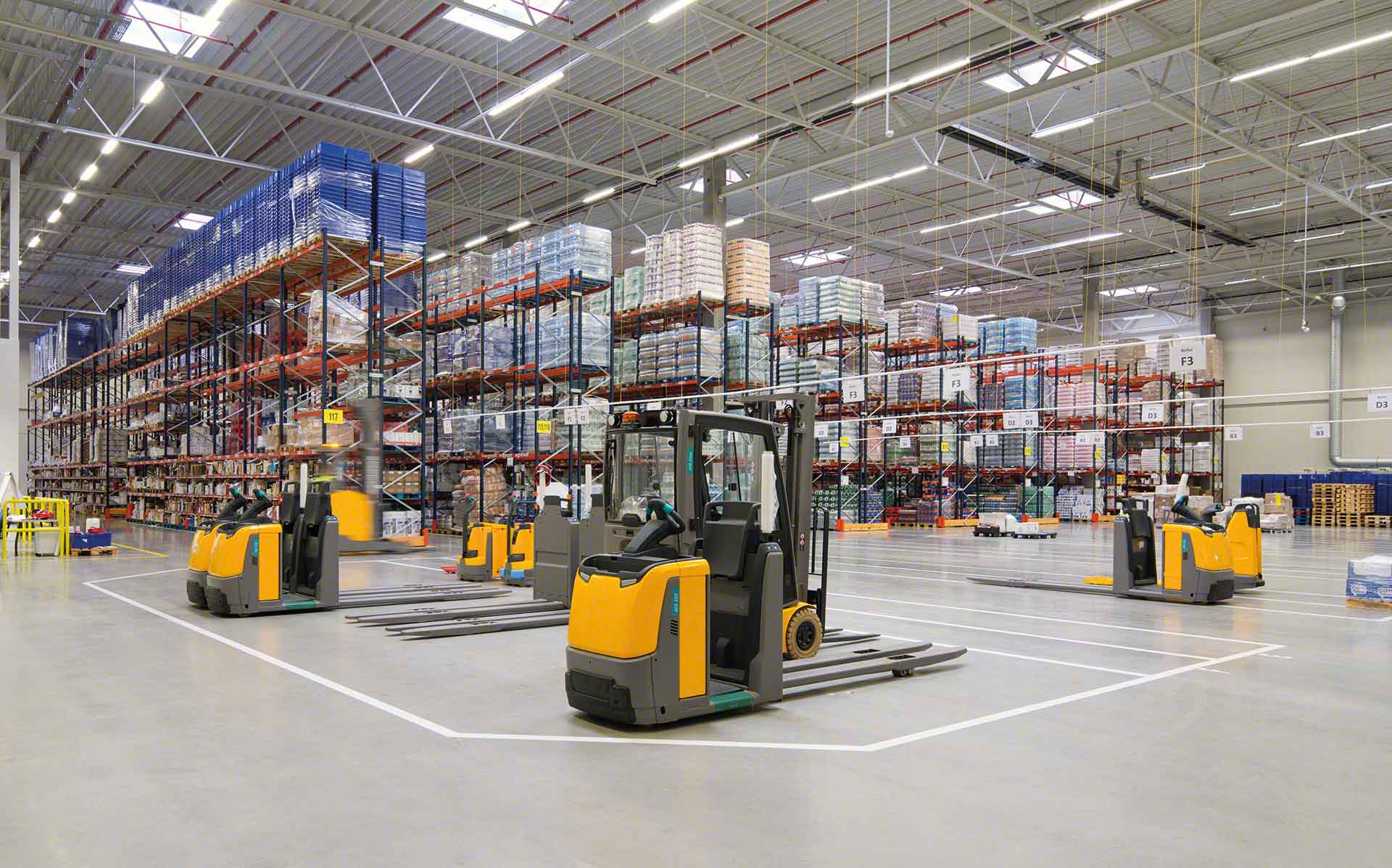 A warehouse filled with lots of shelves and forklifts.