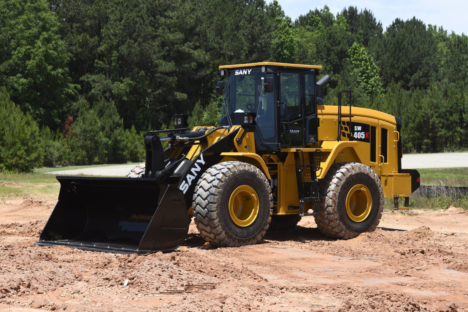 A yellow wheel loader on a dirt path.