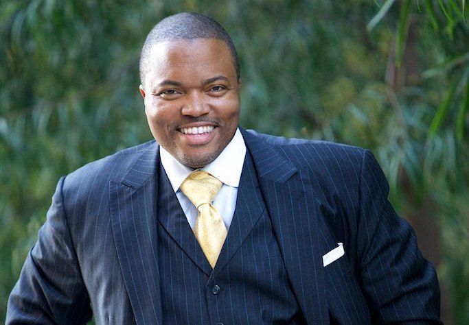 A man in a suit and tie is smiling for the camera.