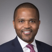 A man in a suit and tie is smiling for the camera.