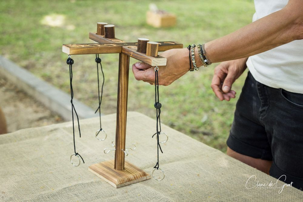 Personne jouant au lancer d'anneaux. Support en bois marron avec anneaux suspendus. Extérieur, sur la pelouse.