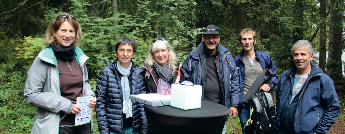 Un groupe de personnes se tient autour d'une table dans les bois.