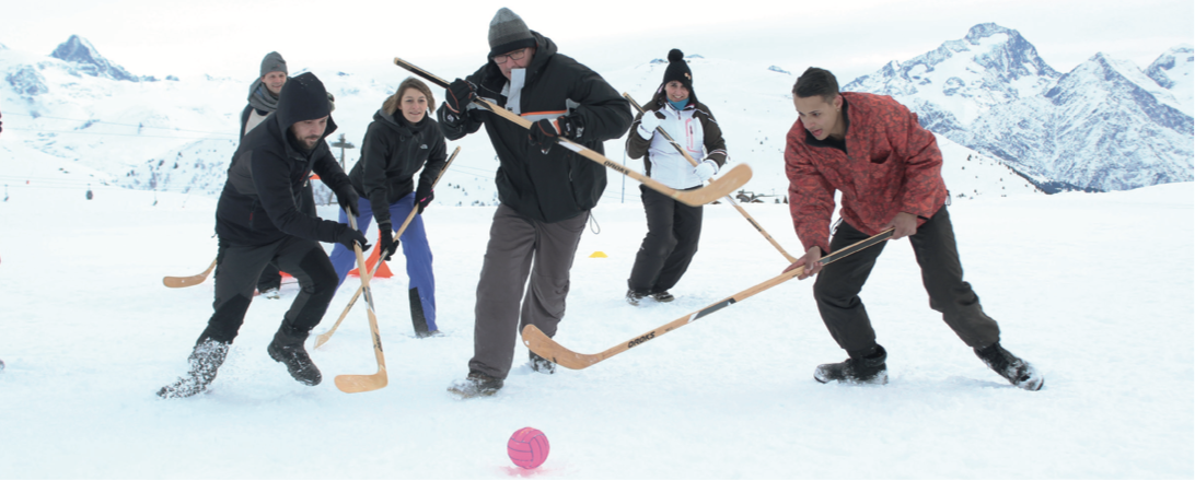 Un homme est debout dans la neige avec une raquette.