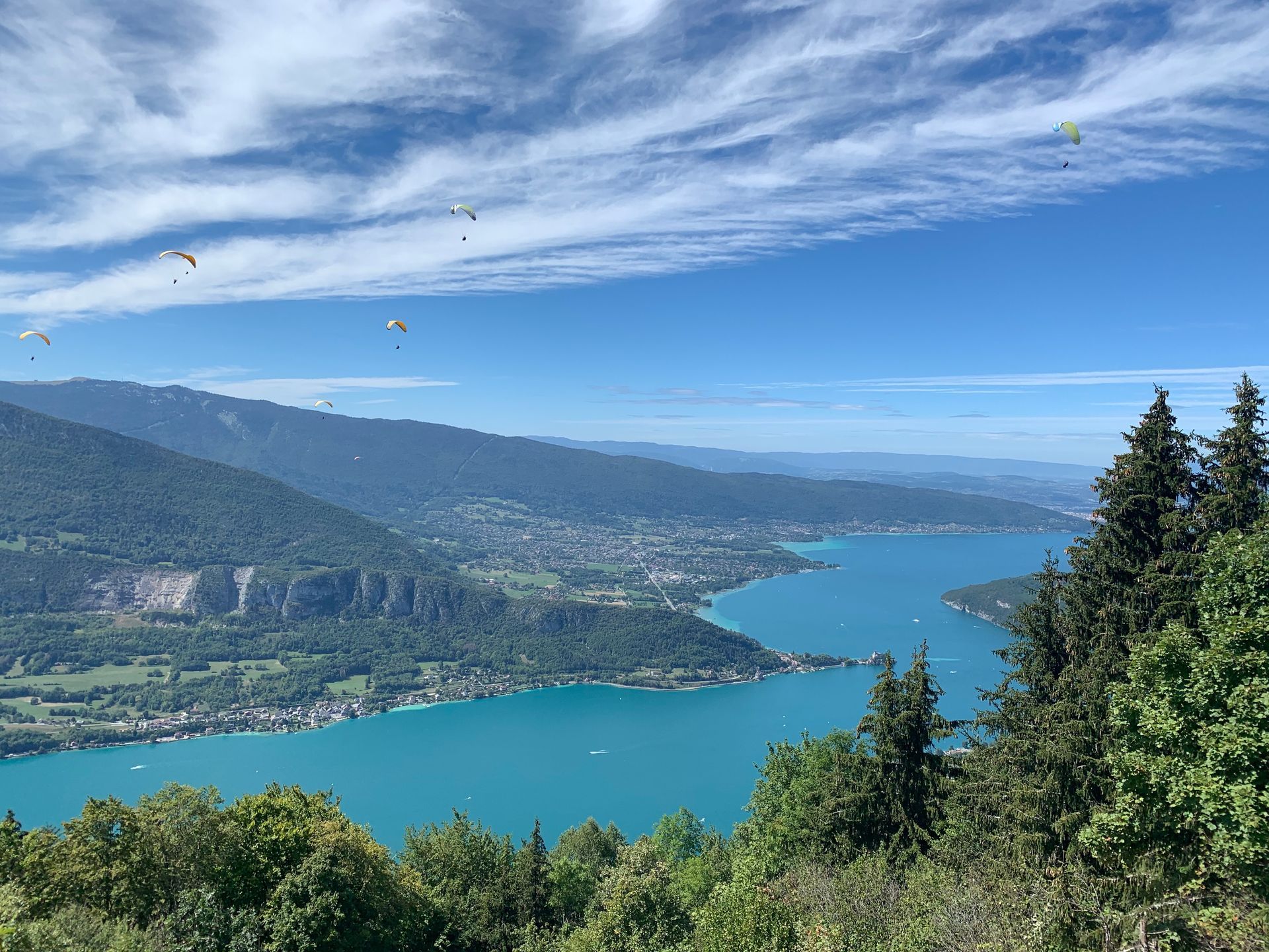 Une vue sur un lac entouré de montagnes et d'arbres.