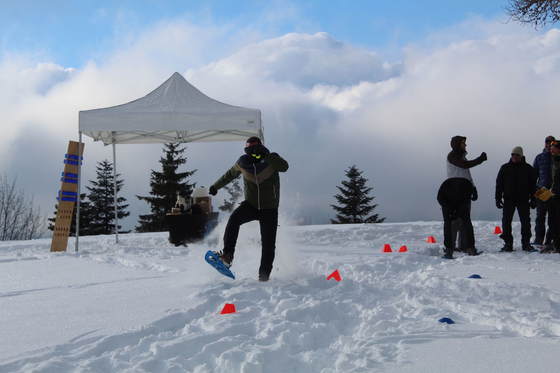 Un homme est debout dans la neige avec une raquette.