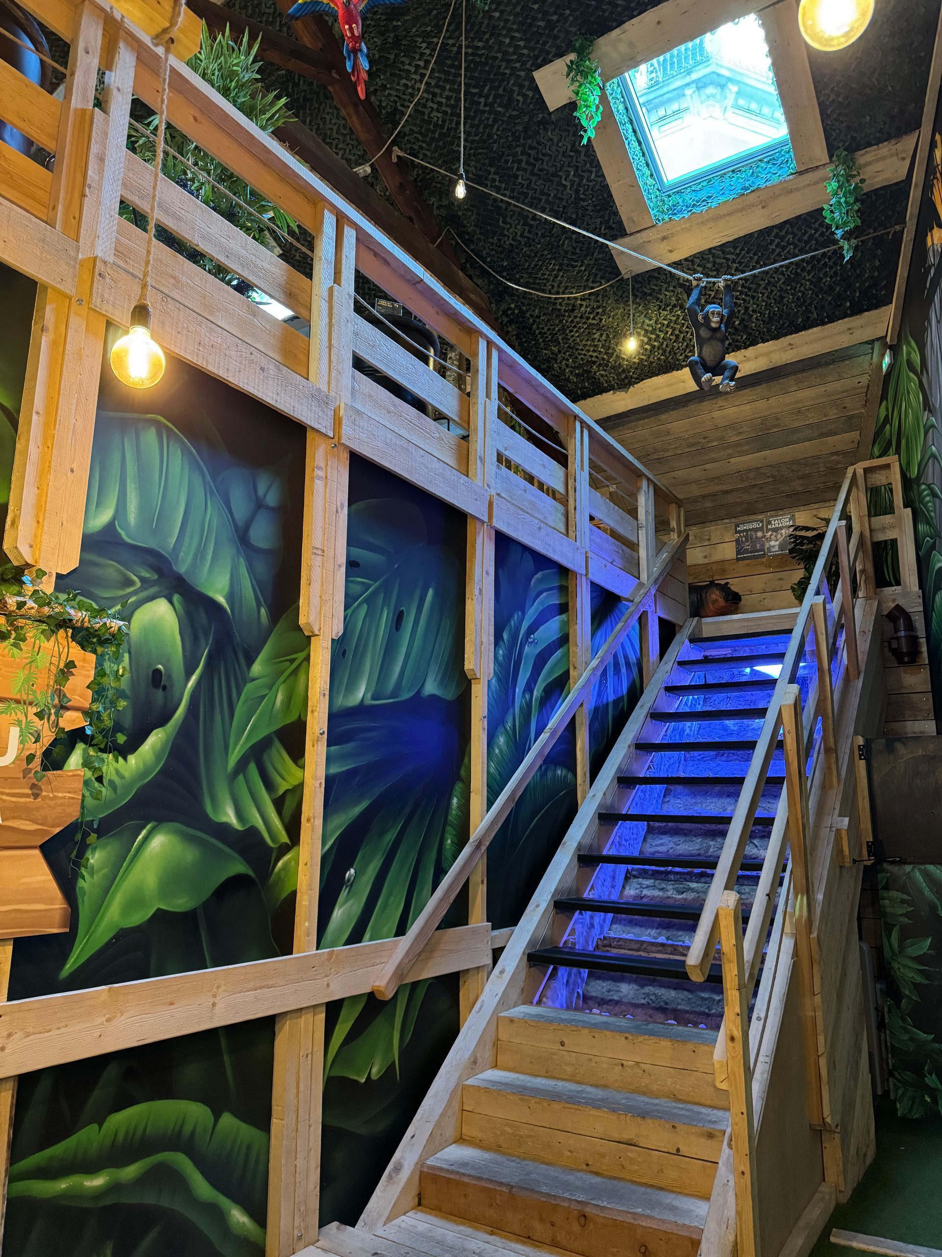 Un escalier en bois avec une rampe et un tableau au mur.