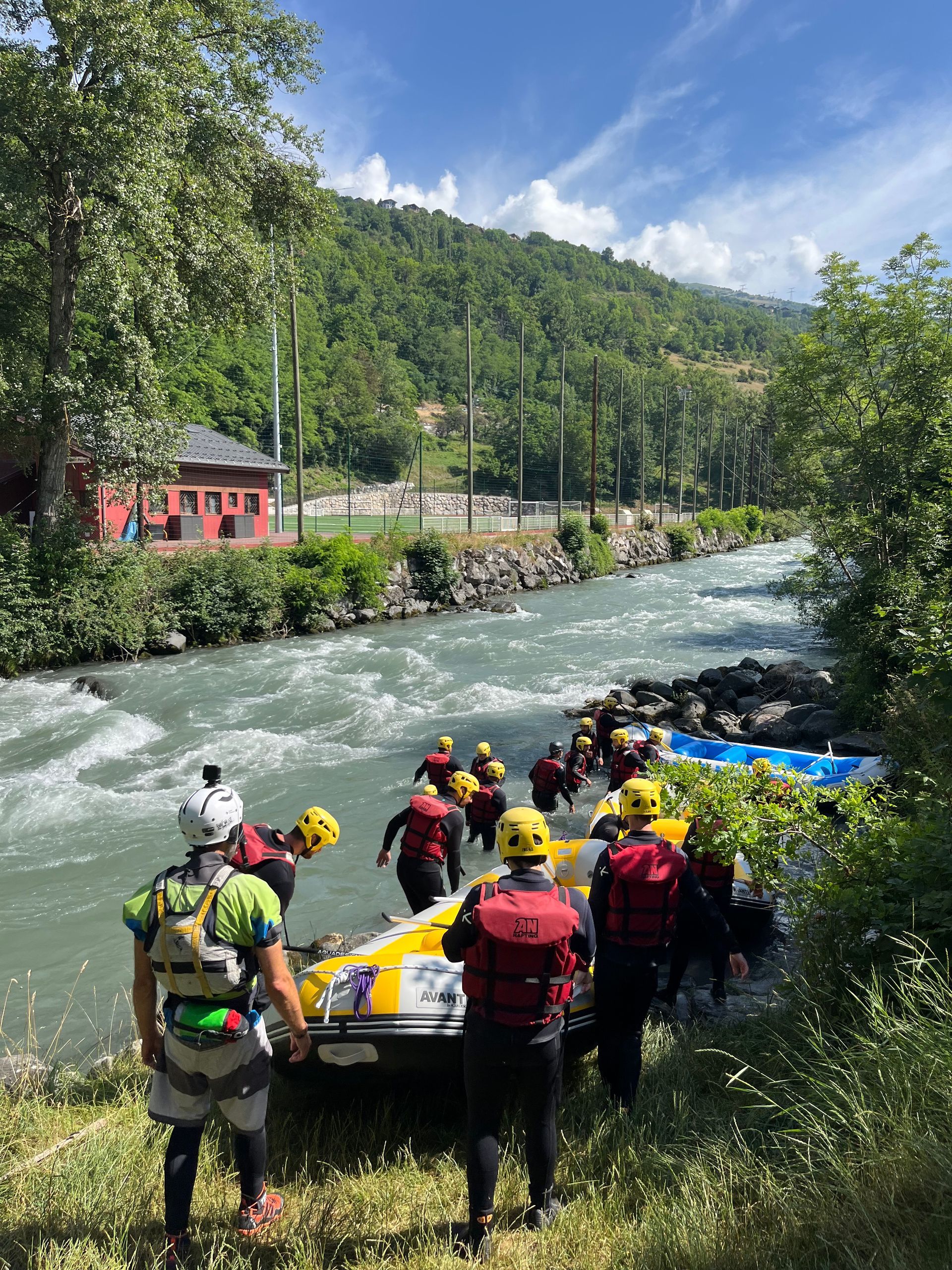 Un groupe de personnes se tient à côté d'un bateau dans une rivière.