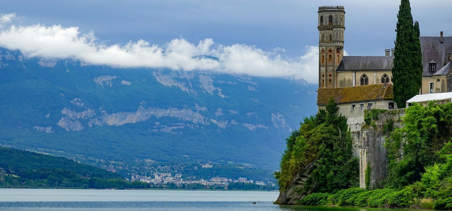 Un château est assis au sommet d'une falaise surplombant un lac.