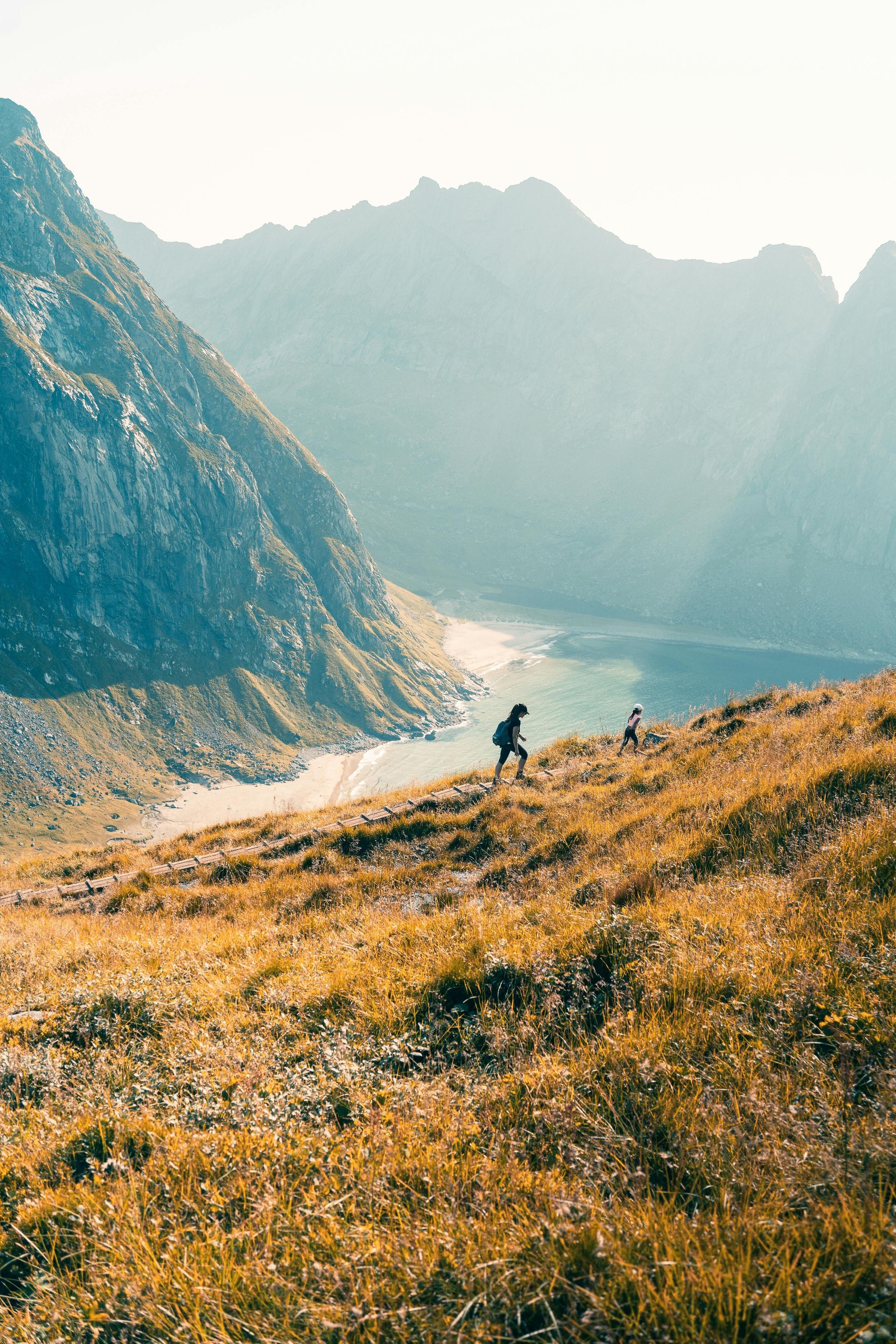 Une personne marche sur une colline dans les montagnes près d'un lac.