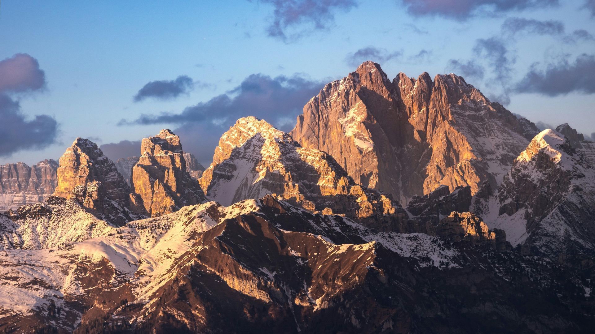 Les montagnes sont couvertes de neige et le soleil brille sur elles