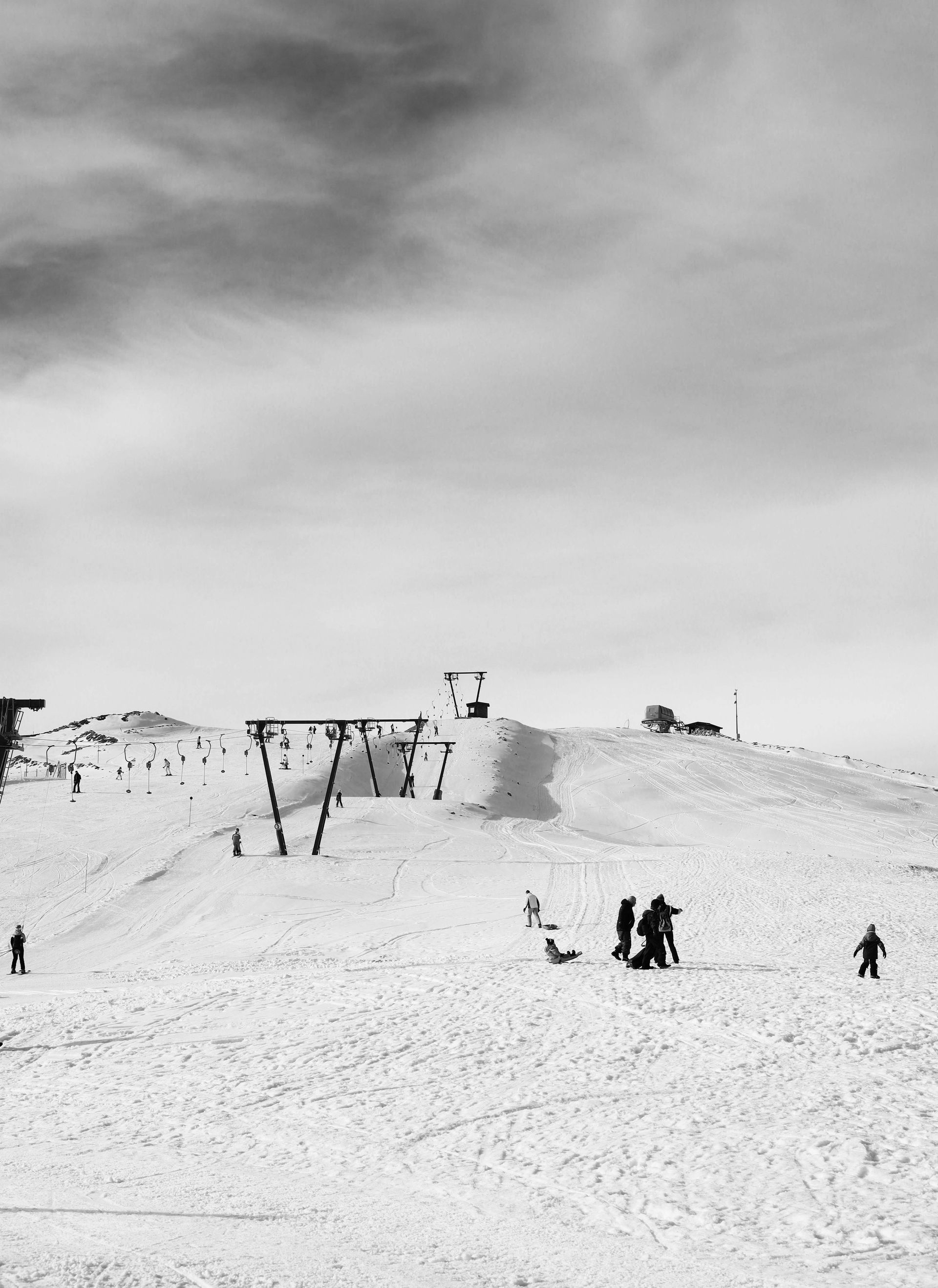 Une photo en noir et blanc de personnes skiant sur une pente enneigée.
