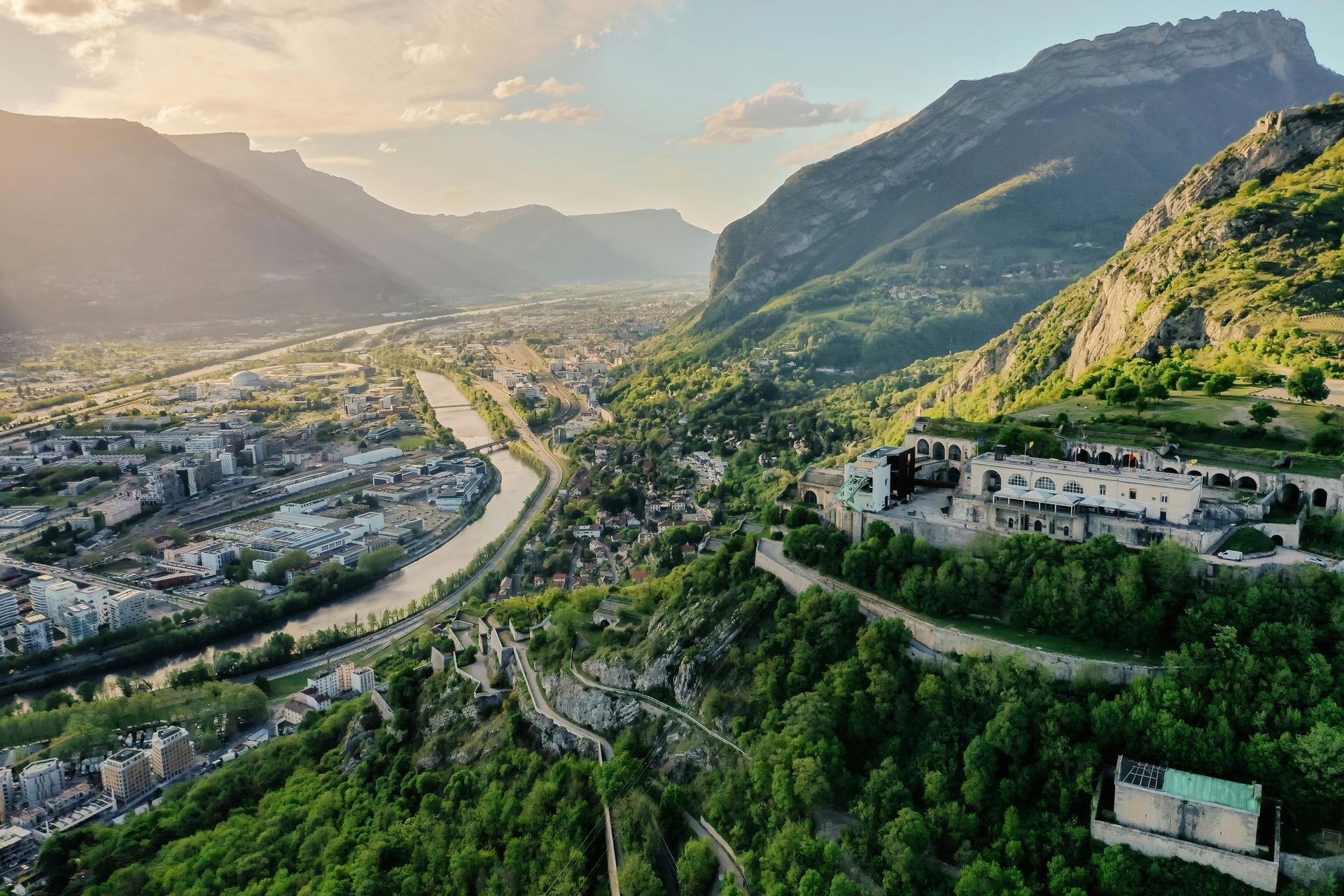 Une vue aérienne d'une ville entourée de montagnes et d'arbres.