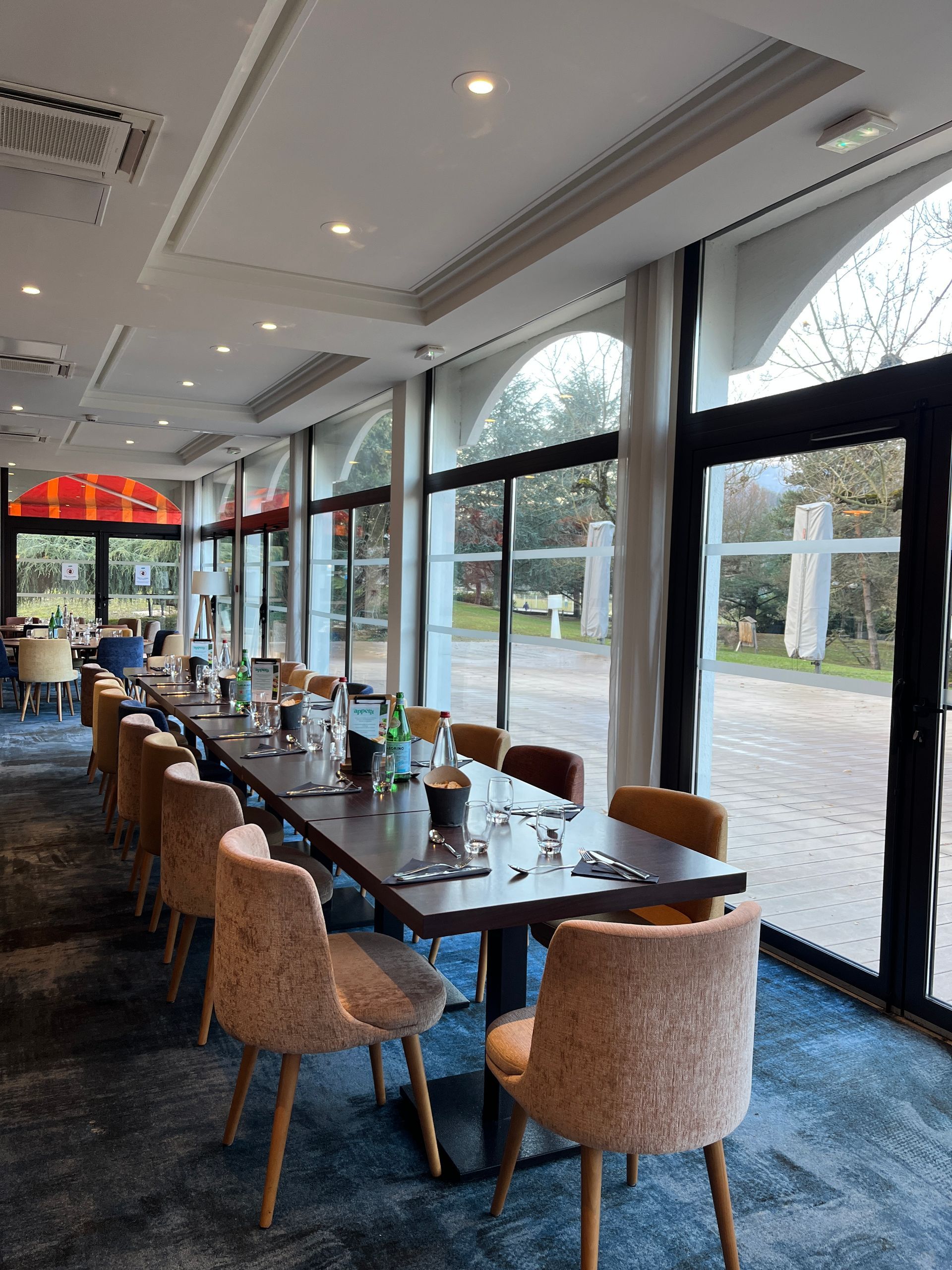 Scène de nuit enneigée avec tipi, structure en bois et guirlandes lumineuses ; arbres en arrière-plan.