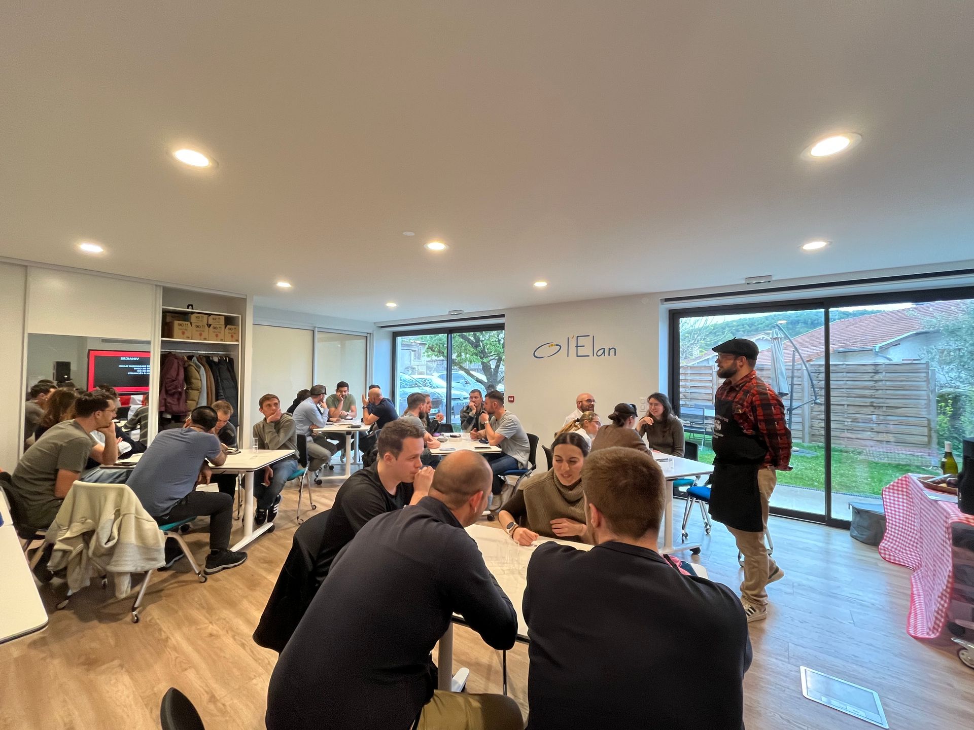 Un groupe de personnes sont assises à des tables dans une pièce.