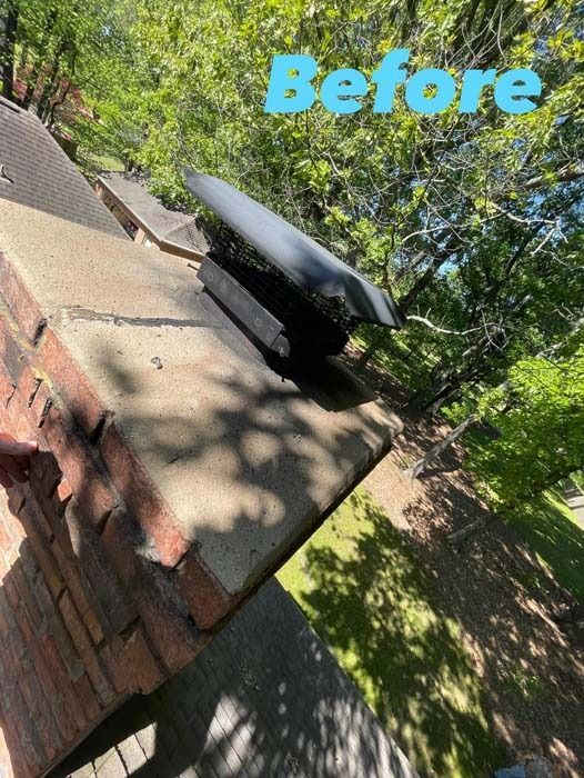 Brick chimney with broken black flashing, viewed from above with trees in the background.