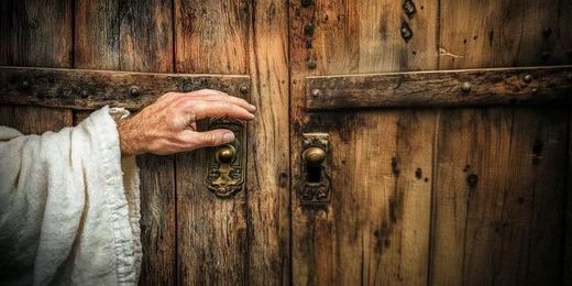 This is a photograph of hands opening a wooden door.