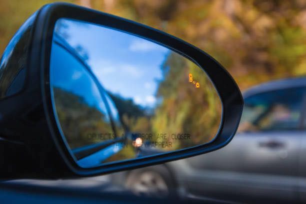 This is a photograph of a side mirror on a car - you can see what if behind in the mirror.