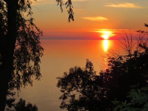 This is a photograph of the sun setting over Lake Huron..