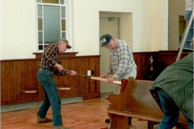 This is a photograph of 2 men working inside the church.