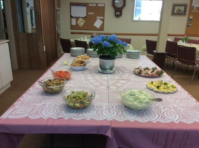 This is a photograph of a table set with salads.