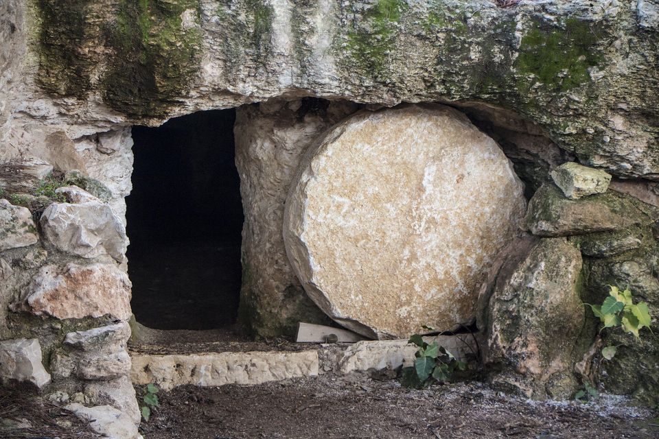 This is a photograph of a tomb with the stone opening pushed to the side.