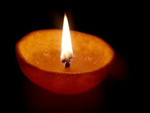 This is an image of a very simple oil lamp with a bright flame.