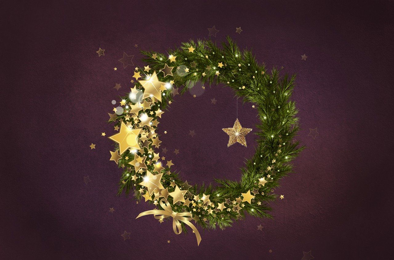 This is a photograph of a Christmas wreath full of greenery and stars.